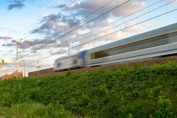 a speeding train blurred in the light of the setting sun