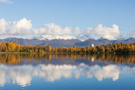 City Park Lake with Mountain Range in Autumn, Anchorage. Urban Life in Harmony with Nature, Alaska Landscape. Autumn Reflections of Anchorage and Chugach Mountains.