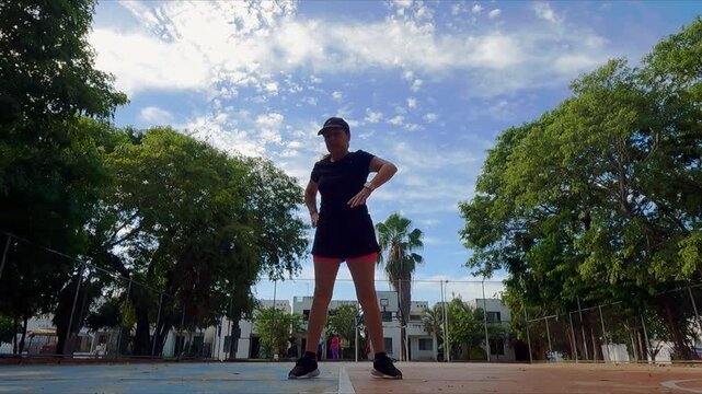 Senior woman exercising by trying to touch her toes on a sunny day