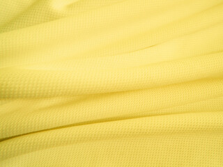 Yellow fabric background. Wavy cloth texture