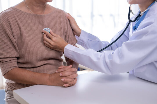 Doctor checking patient's heart with