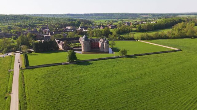 pan castle lavaux sainte anne or ch&acirc;teau de green cover water body fields parked cars trees distant hills to left around right aerial drone panning 
