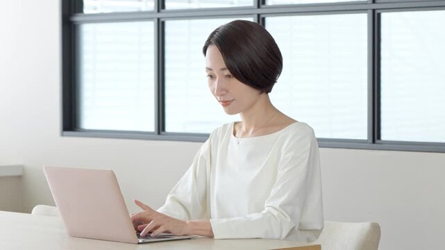 室内でパソコンを使い仕事をする女性