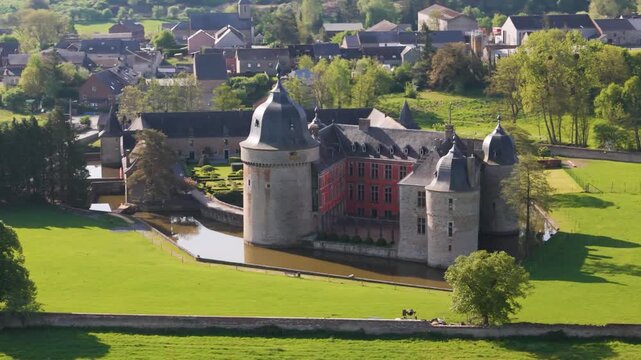 castle lavaux sainte anne or ch&acirc;teau de old building green fields water body town background gardens to left around right close pans aerial drone 