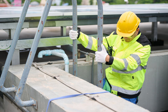 A construction worker in a safety outfit, with protective equipment, climbing the stairs