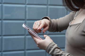 Close-up of a young woman holding a smartphone. Modern lifestyle and technology concept showing communication, social media and mobile connection.