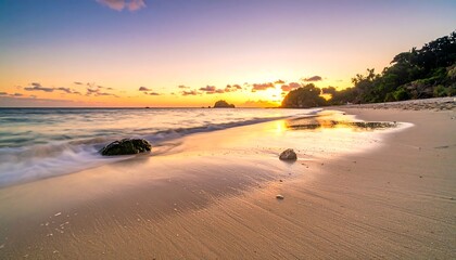 A tranquil beach scene showcases golden sands meeting gently lapping waves under a colorful sky