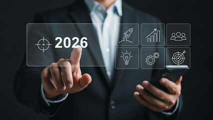 Businessman touching digital interface with target and innovation icons representing business goals 2026