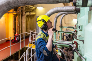 Young marine engineer during his round, checking operational parameters of engine room machineries on a merchant ship. © Mariusz