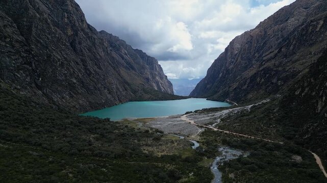 Yungay, Peru:  Forward aerial drone footage of famous Llanganuco lake in Huascaran national park, Yungay. Showing landscape of the valley between mountains with dramatic sky