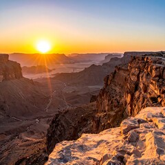 Obraz premium Majestic vista of a canyon at sunrise, with dramatic rock formations and a vibrant sky