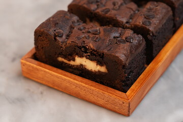 Chocolate banana loaf, sliced, on wood tray, marble backdrop