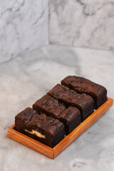 Chocolate banana loaf, sliced, on wood tray, marble backdrop