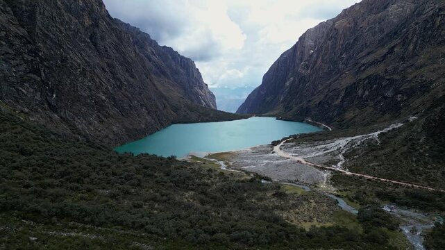 Yungay, Peru: Upward and tilt down aerial drone footage of famous Llanganuco lake in Huascaran national park, Yungay. Showing the valley between mountains with dramatic cloud