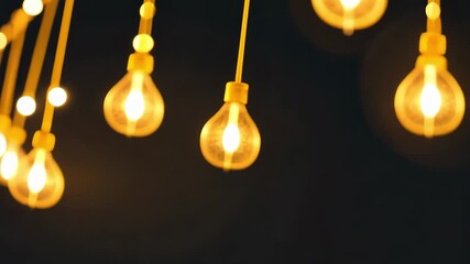 Hanging Edison bulbs gently swaying with warm bokeh on dark background, cozy ambient lighting with minimal copy space - Powered by Adobe