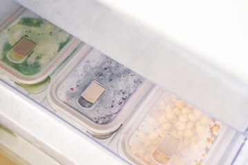 Drawer in freezer with containers of frozen vegetables, top view.