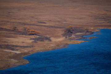 Sikhote-Alin Biosphere Reserve. Autumn forest on the background of a picturesque lake.
