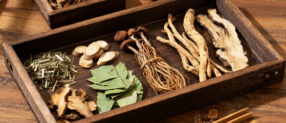 traditional Chinese herbal medicine displayed on wooden tray with dried plants, roots and leaves, natural healing, holistic health, wellness concept, apothecary style.Generated by AI