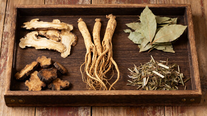 traditional Chinese herbal medicine displayed on wooden tray with dried plants, roots and leaves, natural healing, holistic health, wellness concept, apothecary style.Generated by AI