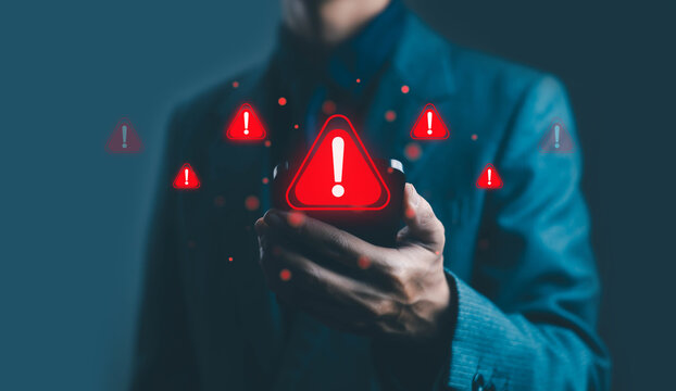 Businessman holding smartphone with multiple red warning icons, representing cybersecurity alert, data breach risk, system error, and digital security notification concept.