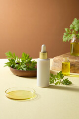 Cosmetic bottle with mugwort leaves arranged beside yellow oil, styled for skincare cosmetic herbal photography.