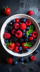 Overhead shot of assorted fresh berries in a white bowl