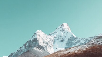 Majestic snow-covered mountain peak rises against clear blue sky, rugged ridges, snow-dusted terrain,