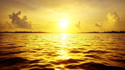A stunning sunset over calm water with golden reflections, scattered clouds in the sky,