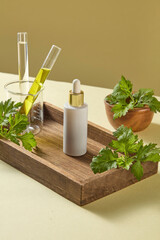 Wooden block styled with test tubes, oil, and mugwort leaves, styled clean for skincare cosmetic science branding. White serum bottle mockup for design