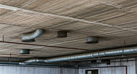 Exposed concrete ceiling with metal ducts