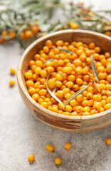 Sea buckthorn berries filling wooden bowl on table