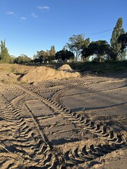 Car tire tracks on the sand in the park