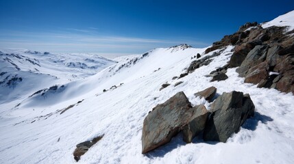 Snowcovered rocky cliffs and vast winter slopes under bright blue sky with tranquil atmosphere