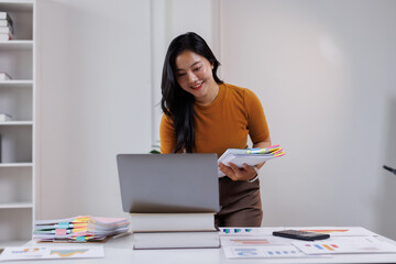 Business woman hands of paper files for searching and checking on laptop unfinished document...