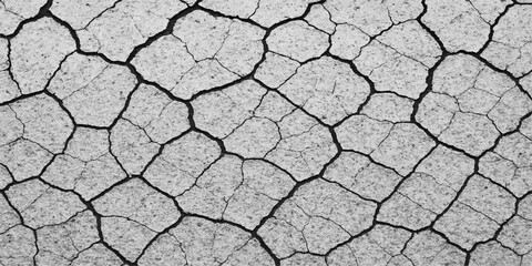 The abstract texture of a drought-stricken, arid cracked clay soil surface displays a striking pattern of deep fissures
