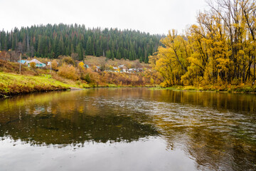 A Serene Autumn Scene by the Tranquil River Surrounded by Beautiful Golden Trees, Capturing the Essence of Natures Peace and Calmness in a picturesque landscape that invites exploration