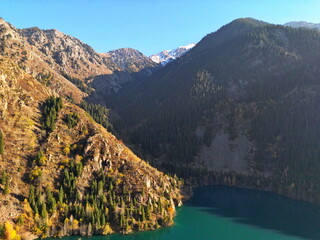 Lake Issyk in the rays of the setting sun. National Nature Park. Mountainous area with different vegetation.