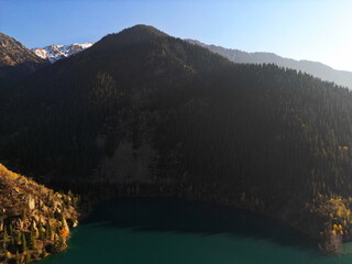 Lake Issyk in the rays of the setting sun. National Nature Park. Mountainous area with different vegetation.
