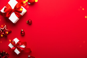 Merry Christmas and Happy Holidays greeting card, frame, banner. New Year. White, red Christmas ornaments and gifts on red background top view. Winter xmas festive holiday theme.