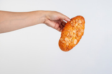 Fresh Rose Croissant with Almonds and hand on White Background