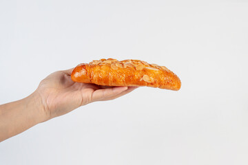 Fresh Rose Croissant with Almonds and hand on White Background