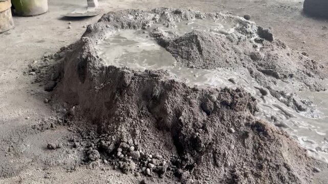 This DIY project mixes cement, sand, and water to make mortar using a trowel and hoe, demonstrating the traditional mixing process.