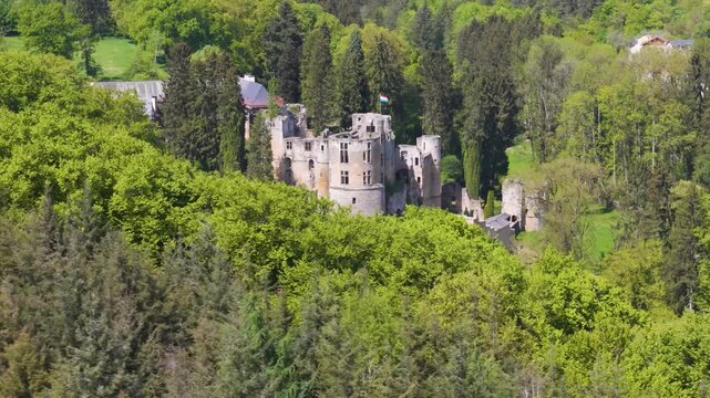 medieval castle beaufort les ch teaux de green cover historical site town below another hill luxembourg to from left around right circles drone 