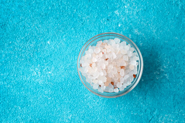 bowl of pink himalayan salt on blue background