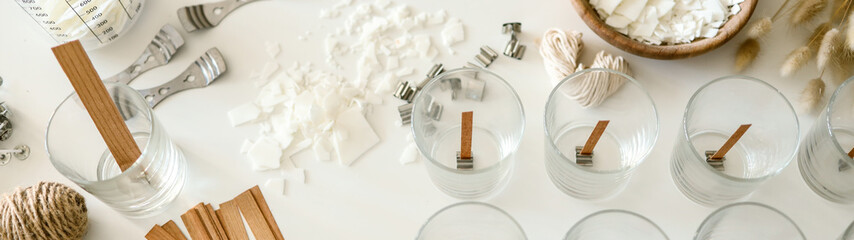 Candle making process with wooden wicks, wax flakes, and glass containers