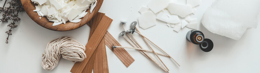 Candle making supplies arranged on a white surface, overhead shot