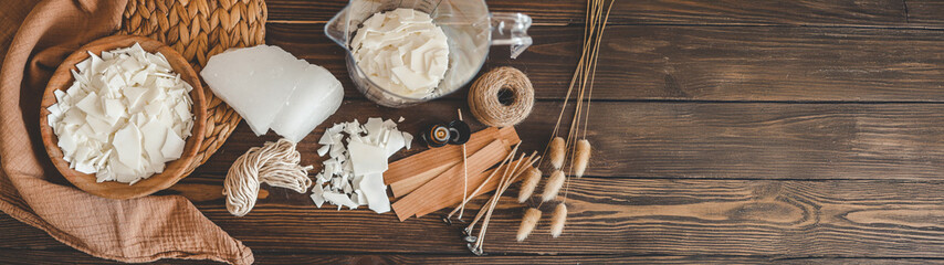 Candle making supplies arranged on a rustic wooden table