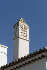 Fototapeta premium Ornate chimney with decorative top structure Terracotta roof tiles below in Portimao, algarve, Portugal