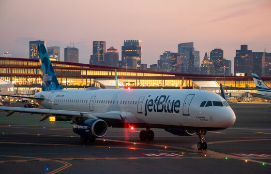 Exterior view of a Jetblue Airbus A321 aircraft Boston Logan International Airport and the skyline of downtown Boston in the background - Boston, Massachusetts, USA
