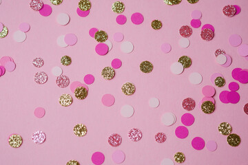 Colorful confetti scattered on a pink background for celebration decoration